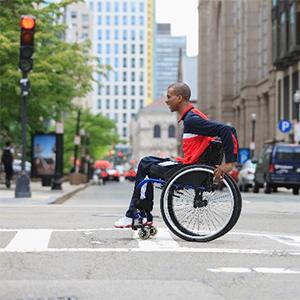 Person crossing a street on a wheelchair